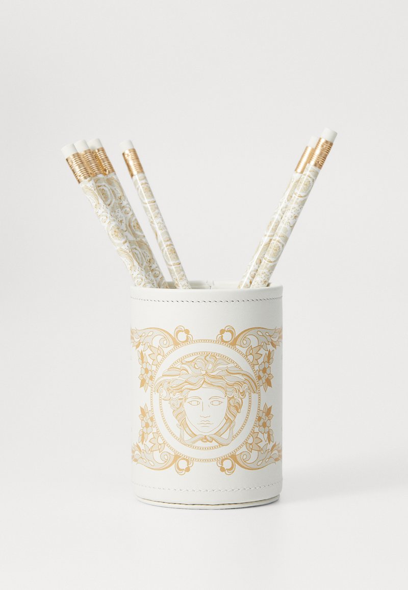 White pen holder with gold decorative design featuring a central face motif. Contains five patterned pens with gold accents.