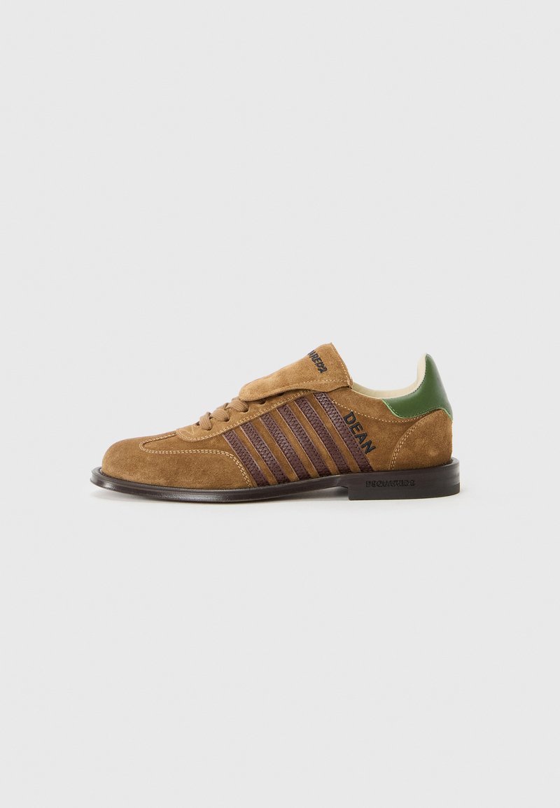 Bruna mockasnicksneakers med mörkvioletta ränder, grön hälflik och snörningsdesign. Har en texturerad yta och gummisula.