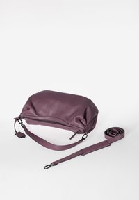 Paarse leren tas met een zachte textuur, ritssluiting en afneembare schouderriem. Heeft een rond model en subtiele stiksel details.