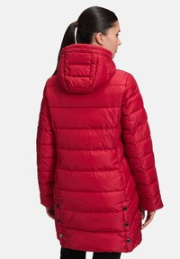 Rote Pufferjacke mit strukturiertem, gestepptem Design, Kapuze und Druckknopf-Akzenten an der Seite. Verfügt über einen mittellangen Schnitt für mehr Schutz.