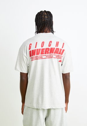 Light gray cotton t-shirt featuring bold red text on the back: "Giochi Invernali" with subtext "Entriamo Nello Sport." Relaxed fit, short sleeves.