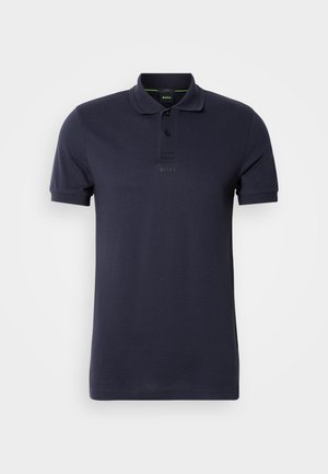 Námornícky modrá polo košeľa vyrobená z bavlny, s plochým golierom, trojbuttonovou légou a vyšívaným logom na hrudi. Krátke rukávy.