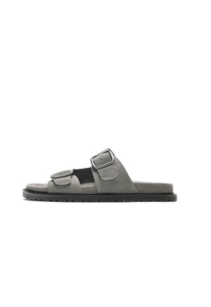 Grå ruskind slide-sandal med to justerbare spænderem og en tekstureret sort sål.