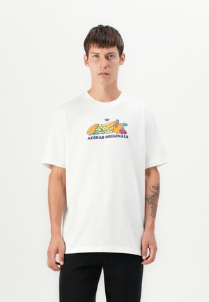 T-shirt bianco in cotone con una grafica colorata di frutta e testo "ADIDAS ORIGINALS", colletto tondo e maniche corte.
