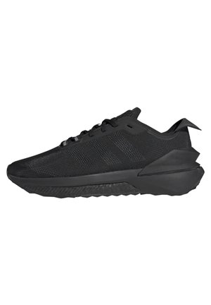 Chaussures de sport noires avec une tige en mesh et des détails texturés. Elles présentent une semelle en caoutchouc épaisse et des accents contrastants sur le talon et la languette.