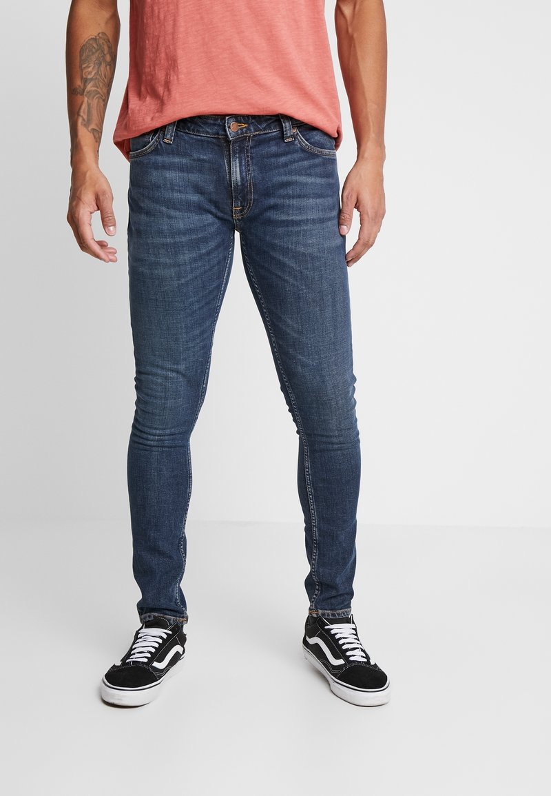 Mörkblå smala jeans gjorda av denim, med en klassisk femfickdesign, lätt blekning och en knappstängning i midjan.