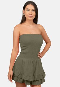 Olijfgroene strapless jurk van gestructureerde stof, met een smock-buste en een gerimpelde zoom, die een vloeiende silhouet creëert.