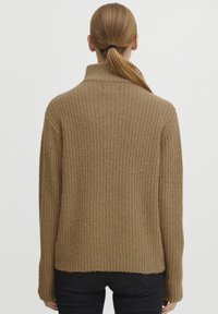 Pulover bej cu dungi, cu gât înalt și mâneci lungi, având un tricot texturat și un tiv ușor scurtat, brut.
