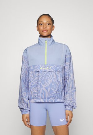 Light blue anorak jacket with abstract floral pattern, half-zip front, high collar, and elastic cuffs. Paired with matching short leggings.