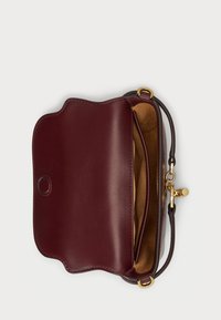 Bordová kožená kabelka cez telo s vlnkovým klapkom, ktorá má zlatý zapínací klip a mäkký semišový interiér. Podšívkový a štruktúrovaný dizajn.