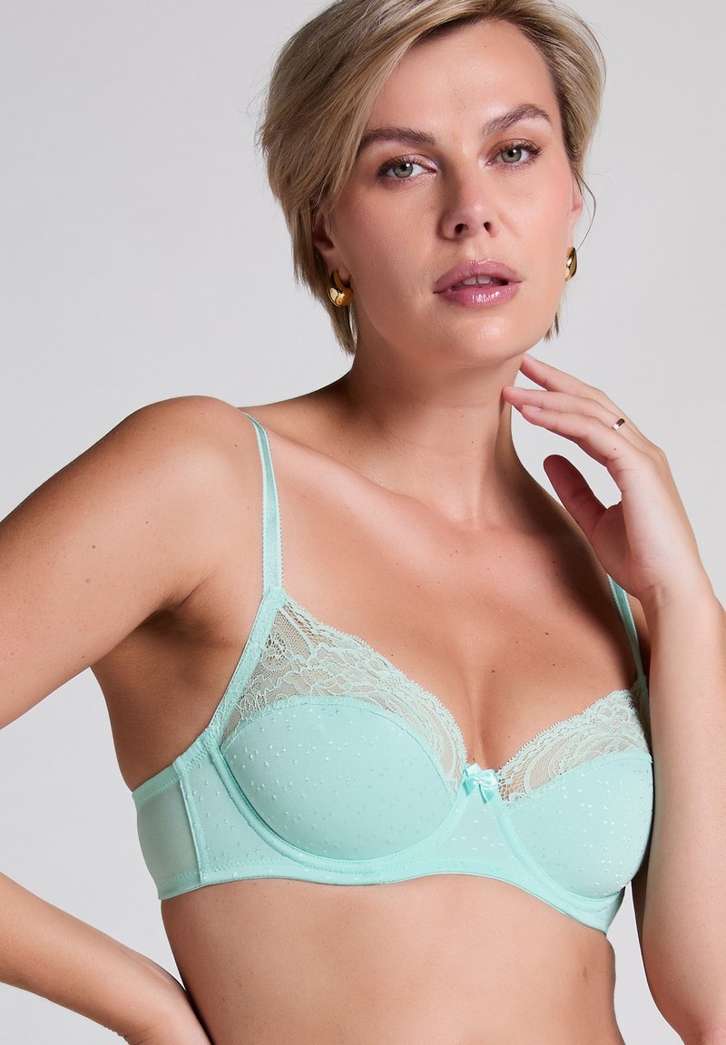 Mintgrön bh med spetskant och prickig textur. Har en hjärtformad rosett i mitten, tunna justerbara band och en strukturerad form.