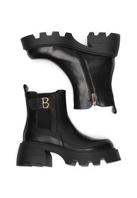 Crne kožne gležnjače imaju bočni zatvarač, masivni gumeni potplat i logo akcent sa strane. Glatka tekstura s sjajnim završetkom.