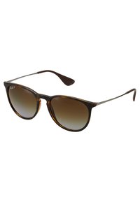 Ochelari de soare cu model țestoasă, cu lentile fie brune în degradé, brațe metalice slabe și o formă clasică de ochi de pisică. Logo-ul de semnătură pe ramă.