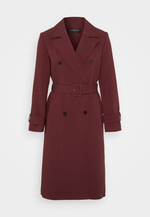 Trench coat bordeaux realizzato in tessuto liscio, con design doppiopetto, cintura e polsini arrotolati. Linee pulite e silhouette sartoriale.
