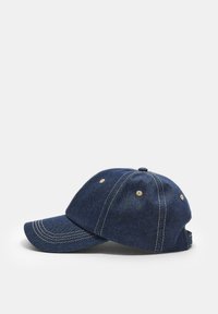 Denimbasebollkeps i mörkblått med gula sömmar, sexpaneldesign och justerbart band bak. Böjd skärm för solskydd.