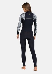 Zwarte wetsuit met patroon op de mouwen, volledig lang, gemaakt van flexibel materiaal. Heeft een hoge hals en een naadloze constructie voor comfort.