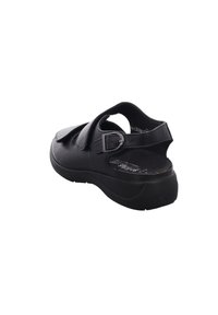 Black sandal made of leather with adjustable strap and metal buckle. Features a contoured sole and open back design for breathability.