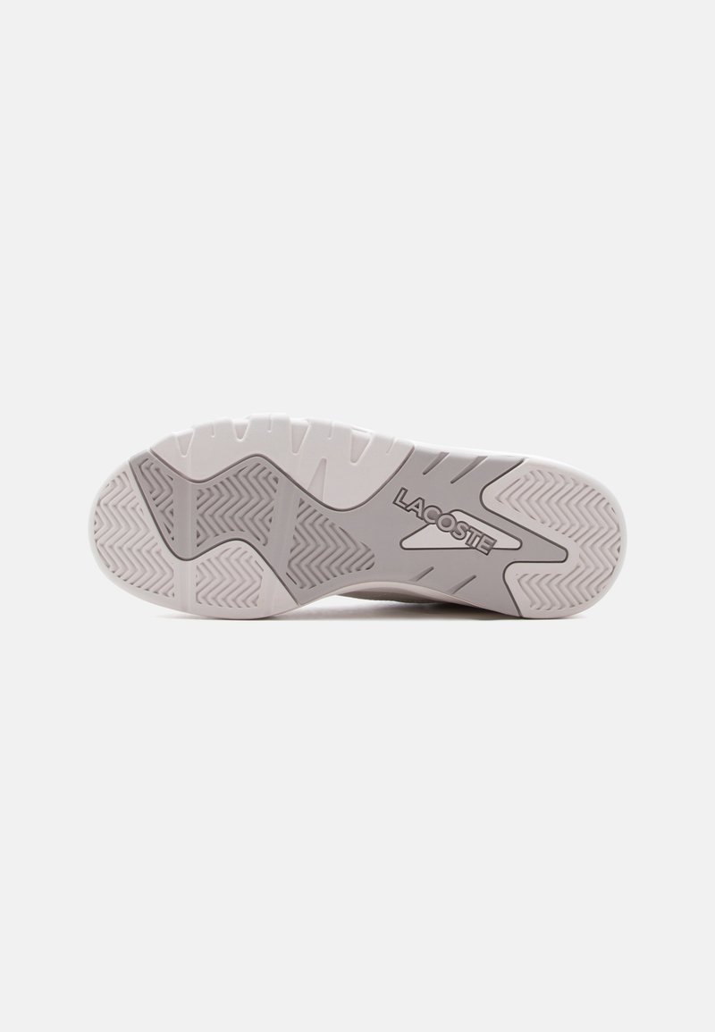 Sole of a white and gray Lacoste sneaker with patterned treads and the Lacoste logo embossed in the center on a plain background.