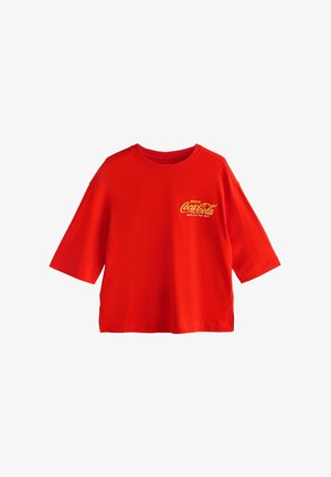 Red short-sleeve T-shirt made of cotton, featuring the text "DRINK Coca-Cola" in yellow on the front. Simple, loose design with a crew neck.