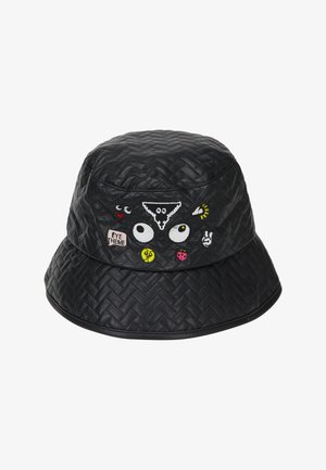 Sort quiltet bucket hat med broderede tegneserieøjne, symboler og tekstlapper i forskellige farver på forsiden.