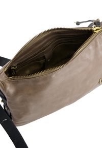 Beige læder crossover taske med guldfarvet hardware, lynlåslukning og flere indre rum til organisering. Glat tekstur, minimalistisk design.