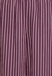 Fines rayures blanches verticales sur un tissu violet froissé, espacées uniformément avec un pli subtil près du centre.