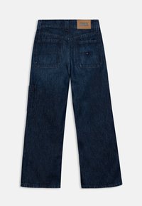 Vaqueros de mezclilla azul oscuro de pierna ancha con corte recto, que cuentan con bolsillos traseros y un pequeño parche de cuero con la marca en la cintura.