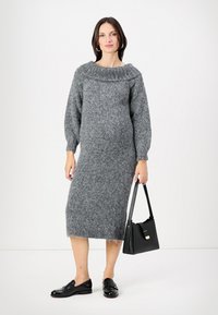 Abito grigio lavorato a maglia con un ampio collo a coste, maniche lunghe a palloncino e lunghezza midi. Abbinato a una borsa nera e scarpe.