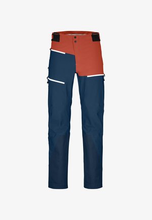 Waterproof cargo pants with a red and navy color scheme. Features multiple pockets, contrasting panels, white accents, and durable material.