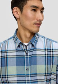Korteblend geruit overhemd met tinten blauw, groen en grijs. Gemaakt van lichtgewicht stof met een button-down kraag en donkere knopen.