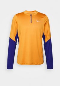 Langærmet atletisk skjorte med orange krop og blå ærmer, med en kvart lynlås og et lille hvidt Nike-logo på brystet.