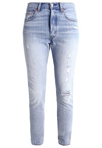 Jeans de mezclilla azul claro con un corte ajustado, que presentan áreas desgastadas, dobladillos deshilachados y un diseño estándar de cinco bolsillos. Cierre de botones.