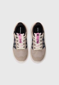 Le scarpe da ginnastica beige e blu navy presentano una tomaia in rete, lacci rosa a contrasto e una suola in gomma testurizzata per una migliore aderenza. Logo del marchio sulla linguetta.