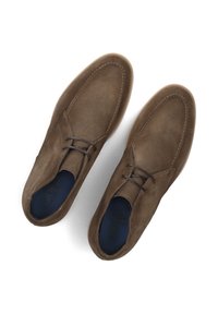 Bruine suède schoenen met een vetersluiting, ronde neus en contrasterende stiksels. Zachte textuur met een strakke, minimalistische stijl.