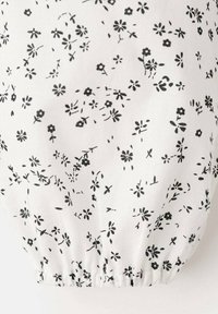 Țesătură albă cu imprimeu floral negru, cu flori mici și frunze. Marginea inferioară adunată.