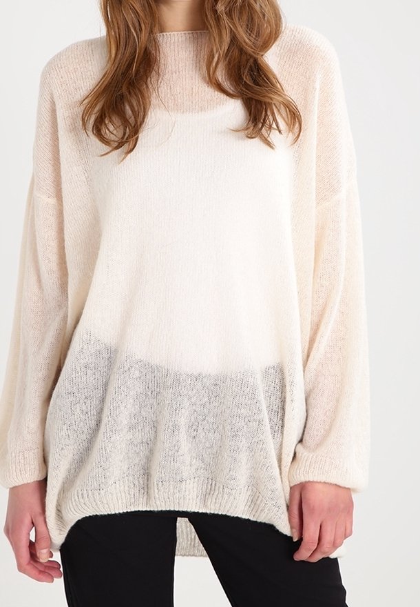 Pull léger de couleur crème avec une coupe ample, des manches longues et un effet ombré gris progressif en bas. Tricot doux et texturé.