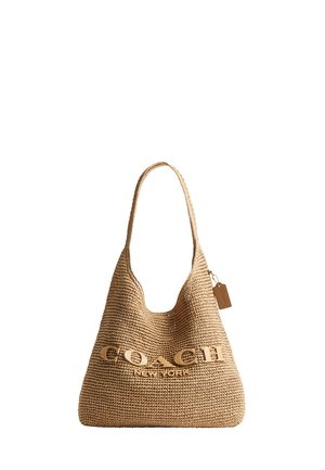 Taske i flet af strå i tan med enkelt skulderrem og stort logo "COACH NEW YORK" på forsiden samt lille hængende mærkat på siden.