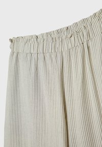 Pantalon à taille élastique en tissu léger, présentant un motif à rayures verticales crème et gris avec une finition texturée.