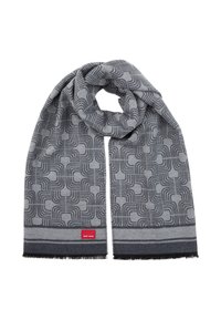 Écharpe grise présentant un motif géométrique avec des lignes arrondies, finie par des bords à franges et une étiquette de marque rouge à une extrémité.