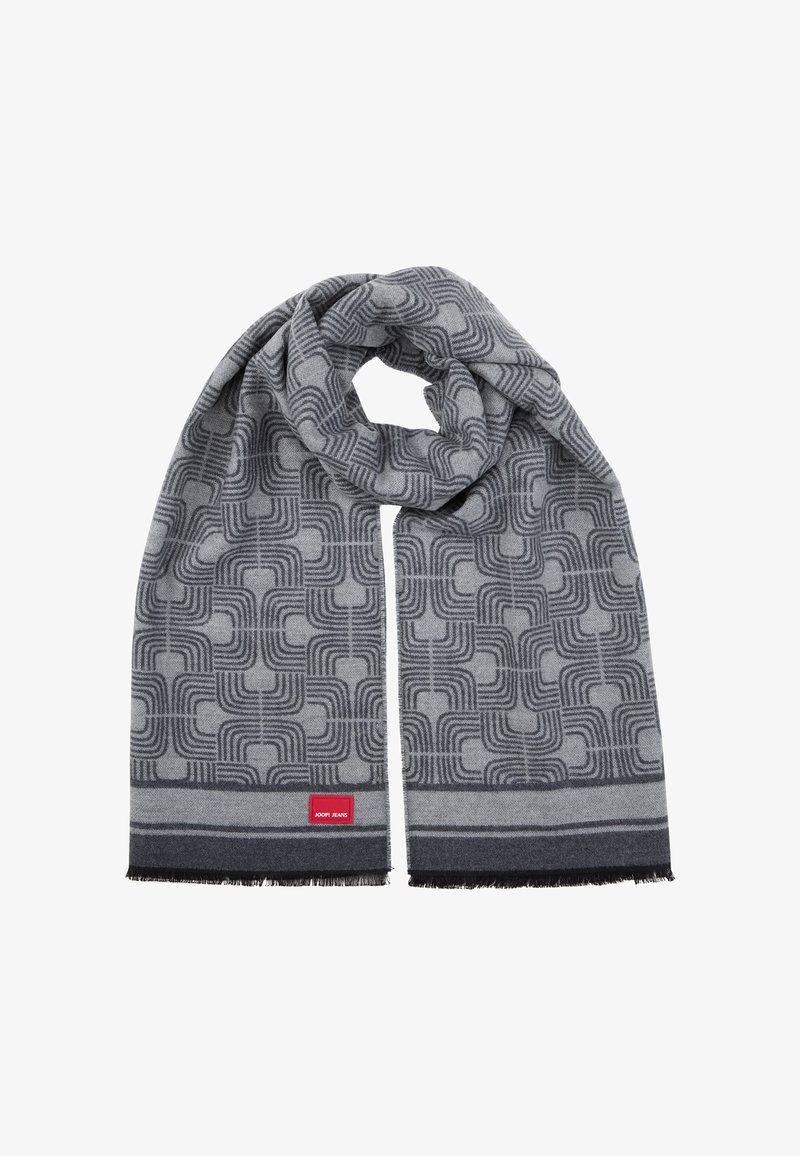 Écharpe grise présentant un motif géométrique avec des lignes arrondies, finie par des bords à franges et une étiquette de marque rouge à une extrémité.