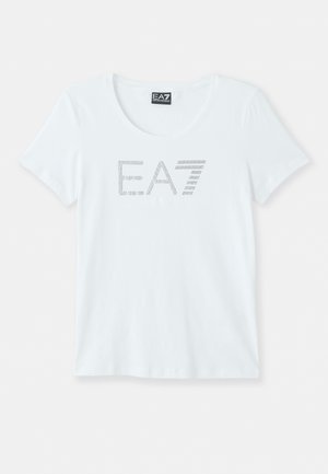 T-shirt blanc à manches courtes avec un col rond, arborant un logo "E.A7" en points argentés sur le devant. Fabriqué en tissu coton léger.