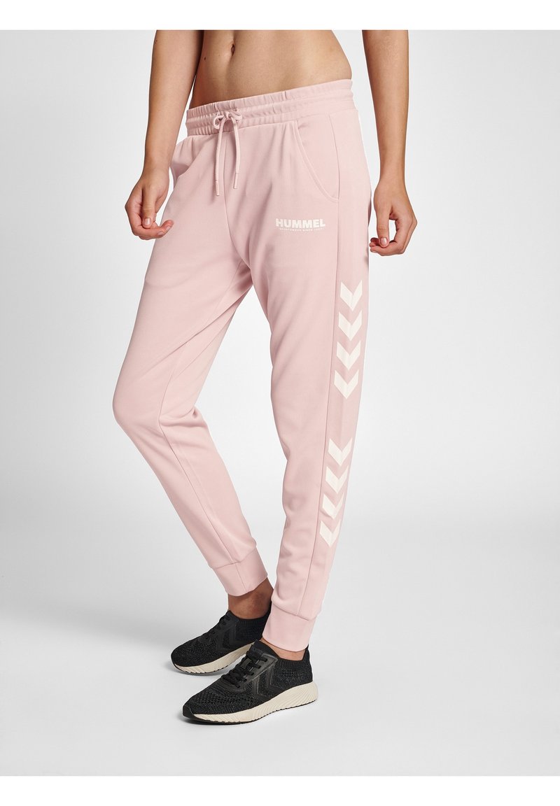 Rosa sweatpants med elastisk midja, med sidfickor och vita chevronränder längs sidan. Tillverkade av mjukt, strukturerat tyg.