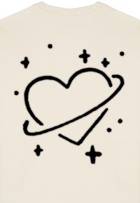 Suéter de color crema con un corazón negro rodeado de un anillo y formas de estrellas, hecho de una tela suave con una textura lisa.