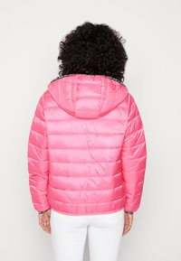 Różowa puchowa kurtka z kapturem, z pikowanym wzorem, błyszczącą fakturą i czarnym wykończeniem przy kołnierzu. Pokazano widok z tyłu.