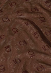 Tela marrón con una superficie texturizada, con un patrón repetido de números "10" en color burdeos oscuro en todo el material.