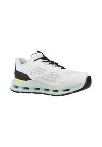 Białe buty sportowe z oddychającą cholewką, wyróżniające się wyciętymi wzorami, czarnymi akcentami oraz miękką jasnoniebieską podeszwą z żółtymi detalami.