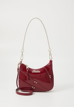Red patent leather handbag with a curved shape, gold chain strap, and decorative buckle accents; features a logo on the front.