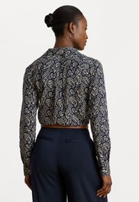 Mornarsko bluza s paisley vzorcem, dolgimi rokavi, ovratnikom in skrajšanim dizajnom. Gladek material z svetlo bež dodatki.