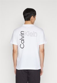 Calvin Klein ANGLED BACK LOGO - Apdrukāts T-krekls - bright white