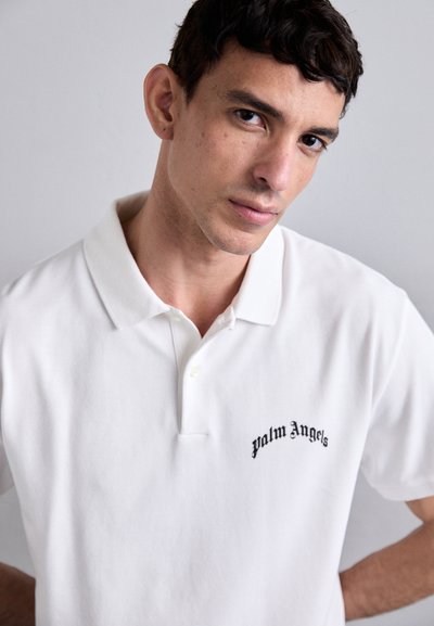 Valge puuvillane polo särk, millel on must tikand "Palm Angels", lühikesed varrukad ja klassikaline krae.